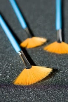Fan shaped paintbrushees on anthracite background