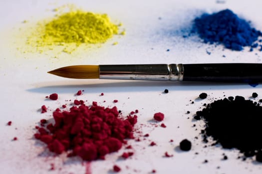 Various pigments colors and brush on a white backround