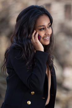 Outdoor of a portrait happy young black  teenage girl using a mobile phone