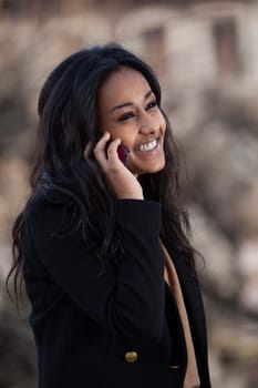 Outdoor of a portrait happy young black  teenage girl using a mobile phone