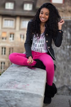 Outdoor of a  portrait happy young african american teenage girl listening to music