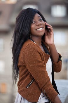 Outdoor of a portrait happy young black  teenage girl using a mobile phone