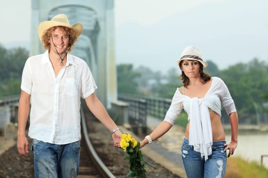 Young couple posing on a train tracks