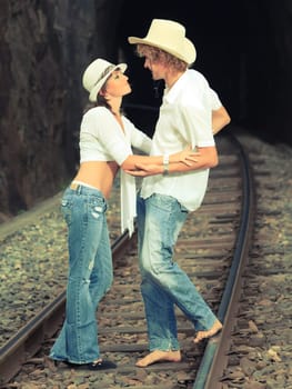 Young couple posing on a train tracks