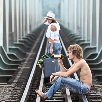 Young woman leaving men on a train tracks