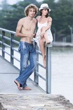 Young couple drinking on a bridge