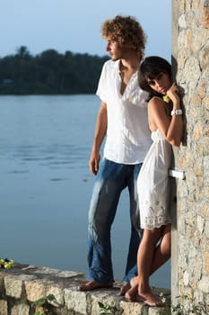 Young couple near the river at twilight time