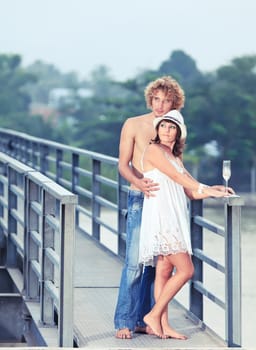 Young couple drinking on a bridge