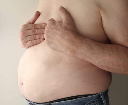 shirtless, overweight man with heartburn or possibly more serious chest pain