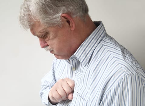 businessman with chest discomfort that could be either heartburn or a heart attack