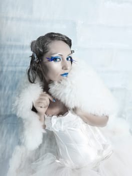 Woman as a snow queen in ice room