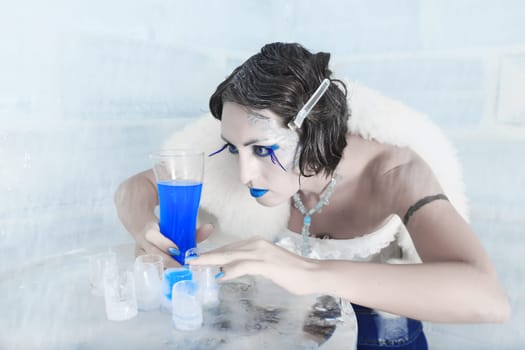 Woman as a snow queen in ice room