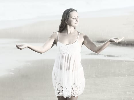 Beautiful woman near the stormy ocean at rain