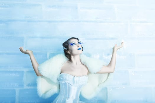 Woman as a snow queen in ice room