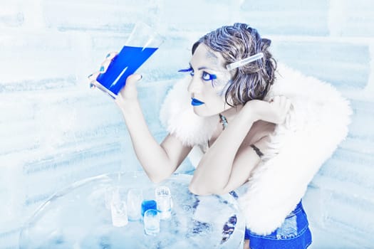 Woman as a snow queen in ice room