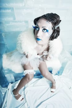 Woman as a snow queen in ice room