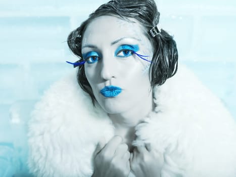 Woman as a snow queen in ice room