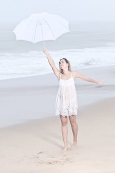 Beautiful woman near the stormy ocean at rain