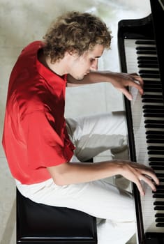 Handsome young man playing on the piano