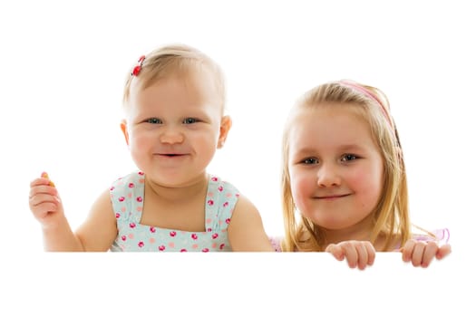studio shot of two sisters behind white board