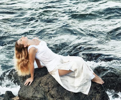 Young beautiful woman posing near the ocean