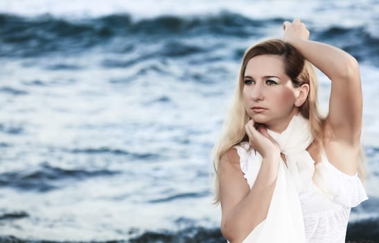 Young beautiful woman posing near the ocean