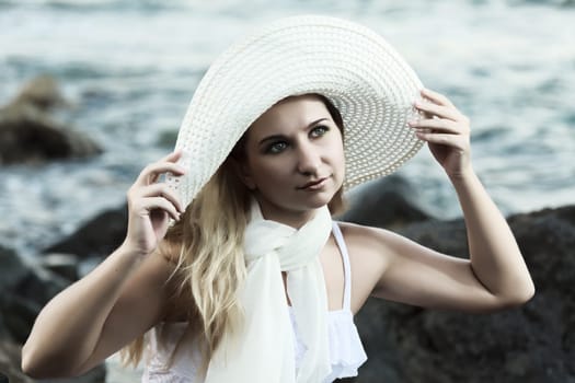 Young beautiful woman posing near the ocean
