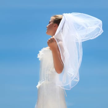 Beautiful young  bride on the blue sky background