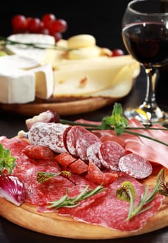 Salami and cheese platter with vegetable and herbs