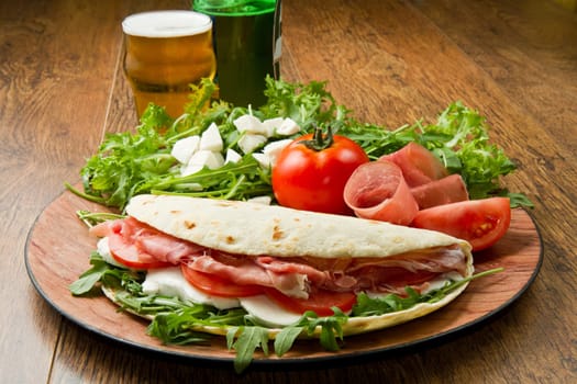 italian piadina with ham, fresh salad and mozzarella cheese