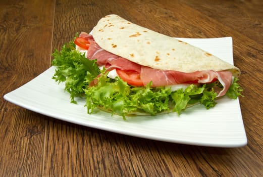 italian piadina with ham, fresh salad and mozzarella cheese