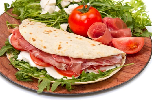 italian piadina with ham, fresh salad and mozzarella cheese