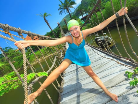 Funny young woman on the suspension bridge