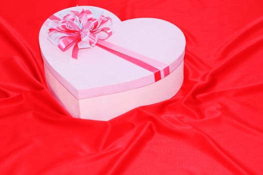 Gift box on the red silk background