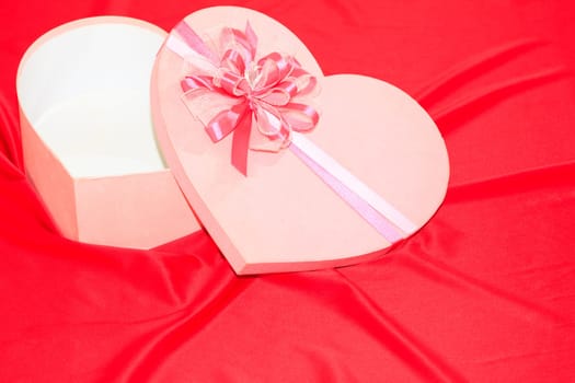 Gift box on the red silk background