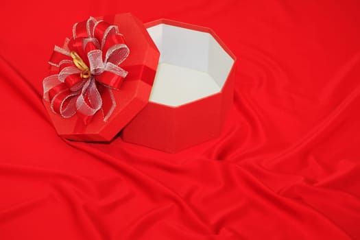 Gift box on the red silk background