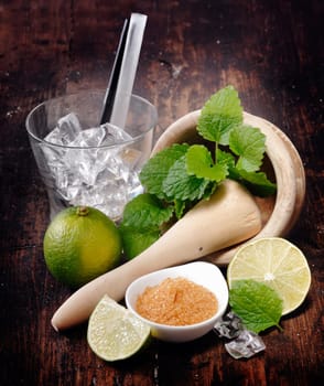 Ingredients for Mojito and Caipirinha. Mortar,Pestle and Lime. Brown sugar and an empty glass with straws