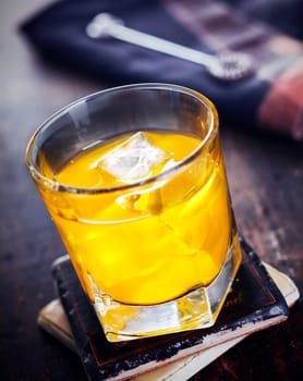 Hard Liquor with Orange juice standing on a coaster, on a wooden, vintage background, for Drink and Cocktail concepts