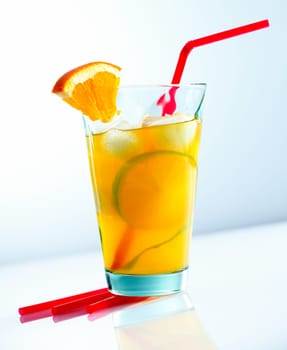 Juicy cocktail with a straw isolated on light blue background.