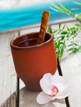 Glass of coconut Milk Drink with a wooden spoon and an orchid. In Front of the sea. For your Drink concepts.