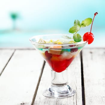 Tropical Fruit Bowl Cocktail with Blue curacao on a Deck at the beach with copyspace