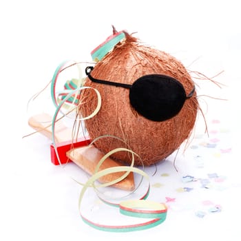 Coconut with an eye patch, confetti and a paper streamer. For little Pirates and caribbean and tropical concepts.