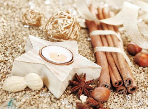 Christmas decorative background with a star shaped candle and mixture of dried spices and nuts