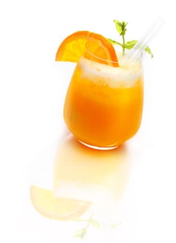 Glass of refreshing orange cocktail topped with ice on a reflective white surface