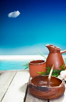 Earthenware mug and jug and small wooden bowl represent the simple cultural luxuries of traveling in tropical islands where natural local handicraft remain important