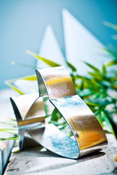 Fresh nautical background with a curvy silver stylised fish shaped cutter with tropical greenery and distant sails in a blue sky