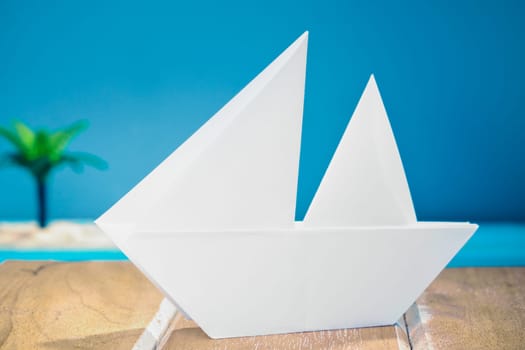 Paper Boat on a wooden deck at the sea.
