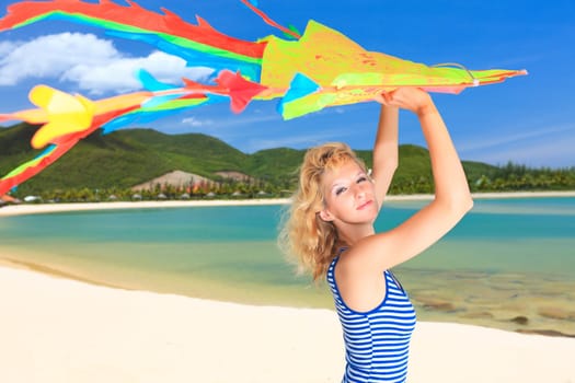 Young woman with kite on the beach