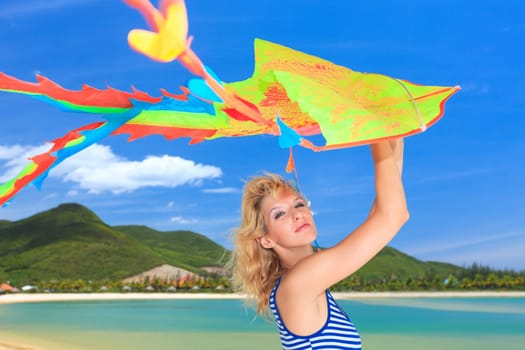 Young woman with kite on the beach