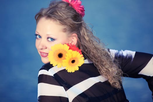 Beautiful woman with flowers. Sea water on background